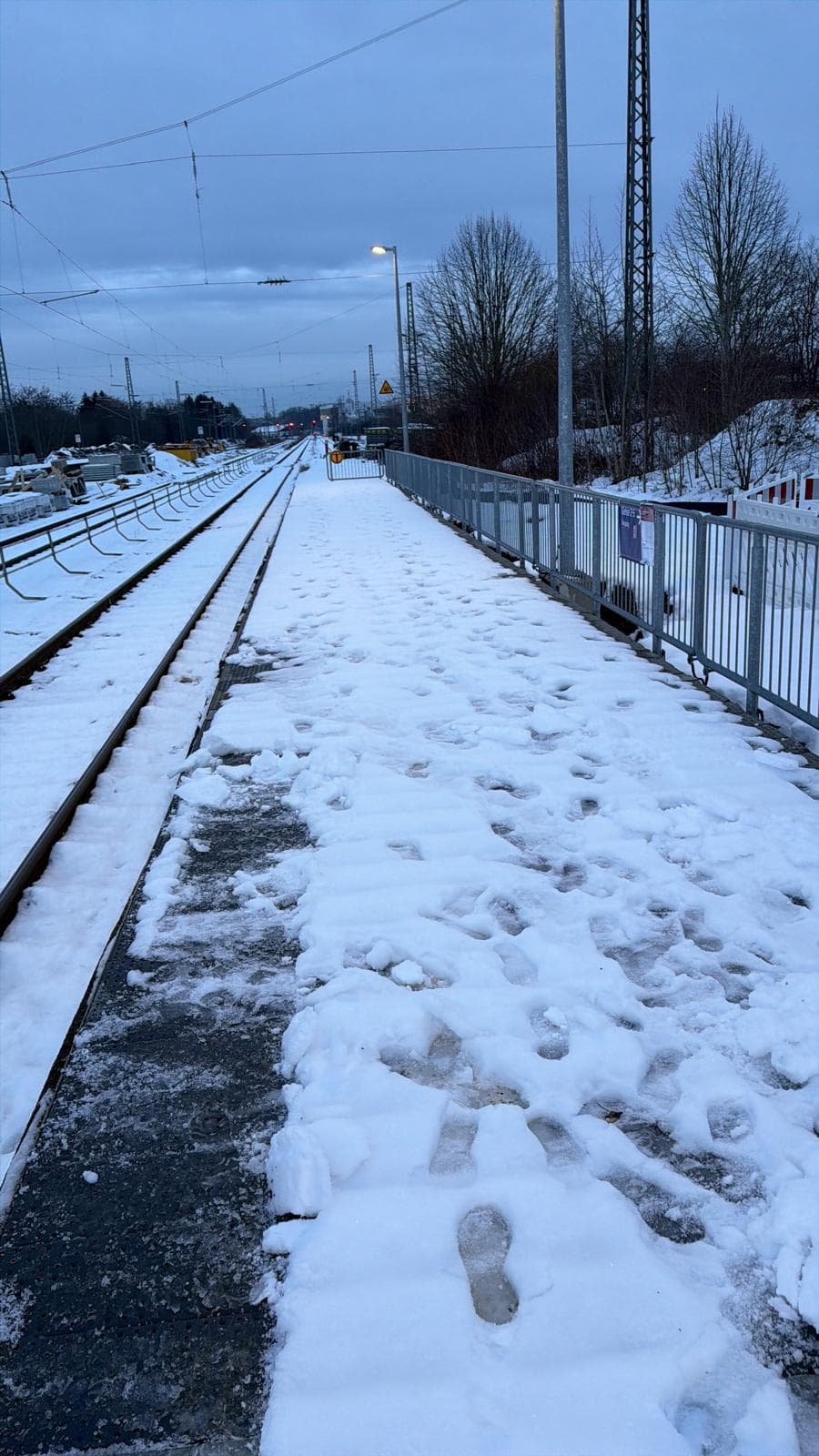 Vorher: verschneiter Bahnsteig mit festgetretenen Fußspuren